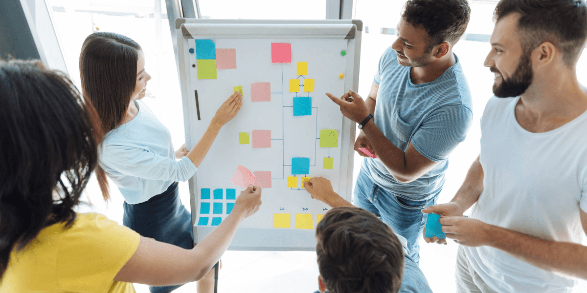 Team collaborating around a whiteboard using coloured sticky notes