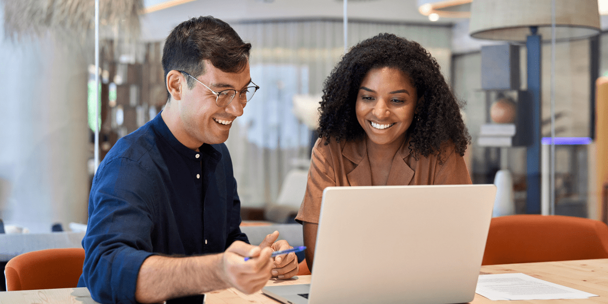 Two colleagues working together with their laptop in an office environment