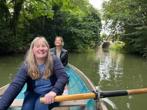 Two Juniper team members in a rowing boat on a river
