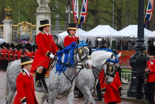 Clare Kavanagh leading beside another rider on grey horses . Leading the coronation procession of King Charles III.
