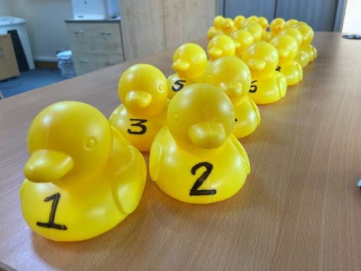 A line of yellow bath ducks on a boardroom table