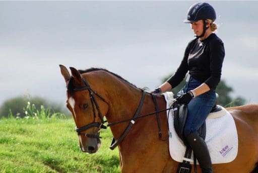 Ginny Howe on a horse with Juniper branded saddle Pad