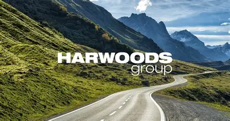 Harwoods Group logo in white with a mountain scene scape behind and a long tarmac road driving through the middle