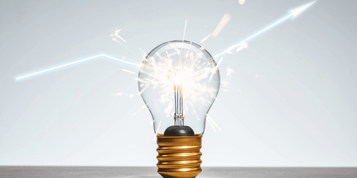 A glowing light bulb emitting sparks and streaks of light, symbolising a bright idea or innovation