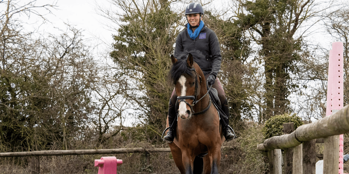 A lady riding on a horse outside
