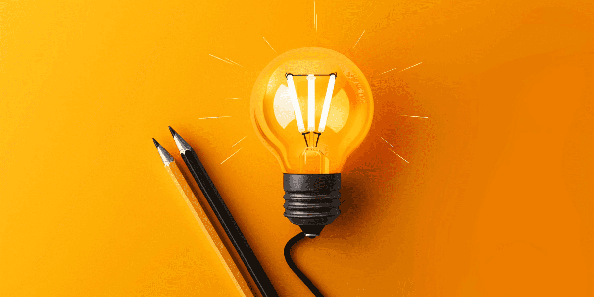 A lit bulb and pencils on an orange background